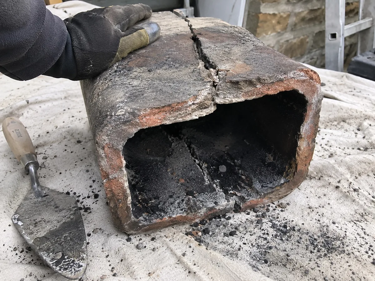 Cracked clay flue tile removed from a chimney during relining