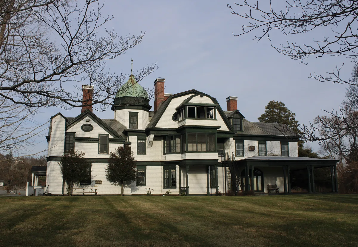 Large shingle-style house with brick chimneys in Balmville, New York