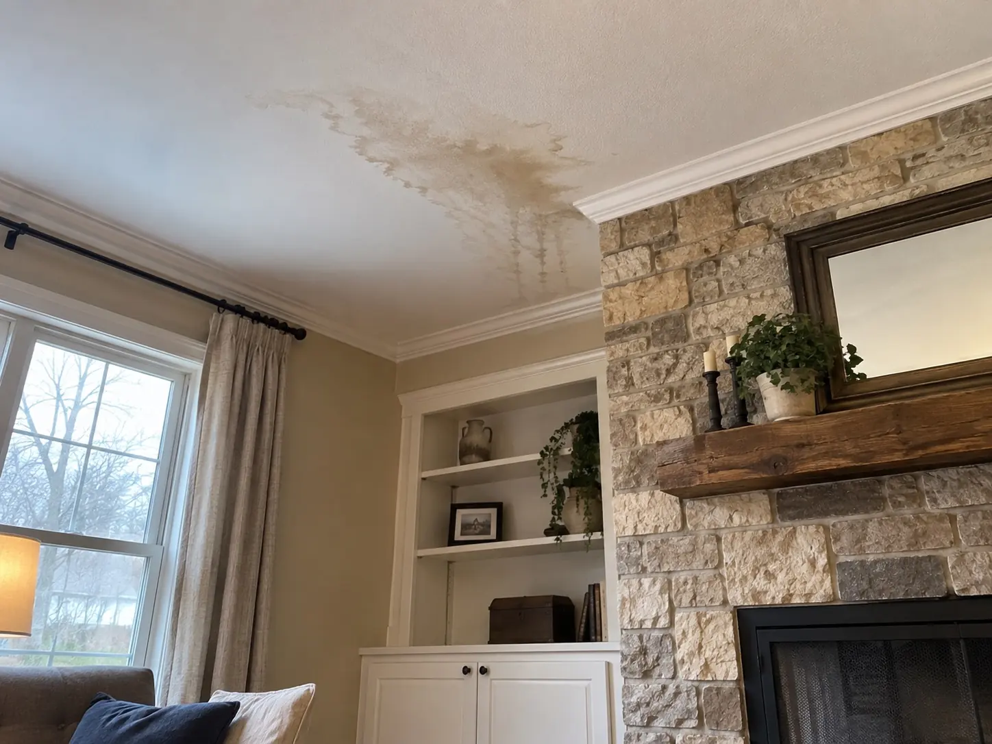 Water stain on an interior ceiling beside a chimney breast